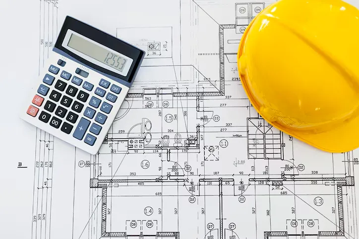 Engineer reviewing mechanical and electrical plan layouts